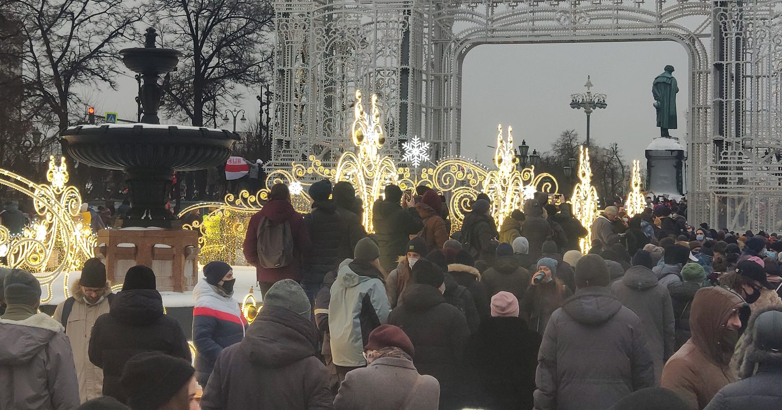 Biało-czerwono-biała flaga białoruskiej opozycji uniesiona na demonstracji.